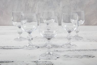 Altı Kristal Kadeh. Beyaz ahşap arka planda altı boş şarap kadehi..