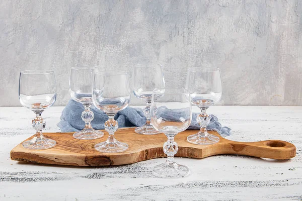 ６つのクリスタル ゴブレット 白い木製の背景に6つの空のワイングラスのセット — ストック写真