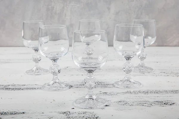 Altı Kristal Kadeh. Beyaz ahşap arka planda altı boş şarap kadehi..