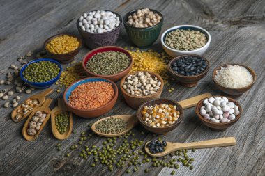 Vegan protein source.Various assortment of legumes, lentils, chickpea and beans assortment in different bowls on wooden table. Top view.