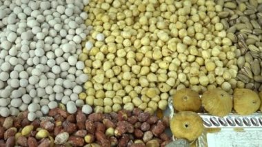 Kamera fındık makro çekim üzerinden hareket ediyor. Çeşitli fındıklar yaklaşıyor. ceviz, badem, fındık ve diğer fındıklar masada kurutulur. Yüksek kalorili vejetaryen yemeği. Kuru fındık. 4K Video.