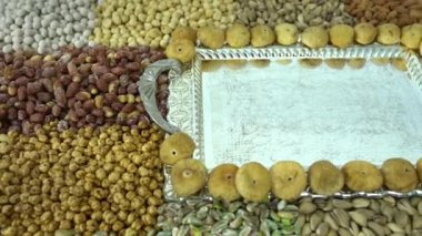 Kamera fındık makro çekim üzerinden hareket ediyor. Çeşitli fındıklar yaklaşıyor. ceviz, badem, fındık ve diğer fındıklar masada kurutulur. Yüksek kalorili vejetaryen yemeği. Kuru fındık. 4K Video.