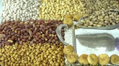 Kamera fındık makro çekim üzerinden hareket ediyor. Çeşitli fındıklar yaklaşıyor. ceviz, badem, fındık ve diğer fındıklar masada kurutulur. Yüksek kalorili vejetaryen yemeği. Kuru fındık. 4K Video.