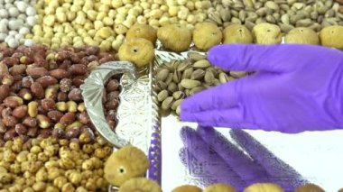 Kamera fındık makro çekim üzerinden hareket ediyor. Çeşitli fındıklar yaklaşıyor. ceviz, badem, fındık ve diğer fındıklar masada kurutulur. Yüksek kalorili vejetaryen yemeği. Kuru fındık. 4K Video.