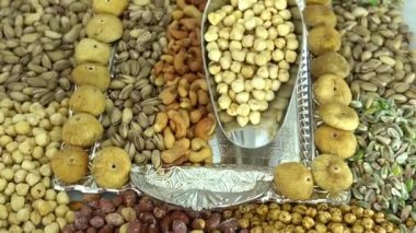 Kamera fındık makro çekim üzerinden hareket ediyor. Çeşitli fındıklar yaklaşıyor. ceviz, badem, fındık ve diğer fındıklar masada kurutulur. Yüksek kalorili vejetaryen yemeği. Kuru fındık. 4K Video.