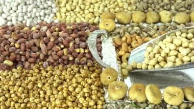 Kamera fındık makro çekim üzerinden hareket ediyor. Çeşitli fındıklar yaklaşıyor. ceviz, badem, fındık ve diğer fındıklar masada kurutulur. Yüksek kalorili vejetaryen yemeği. Kuru fındık. 4K Video.