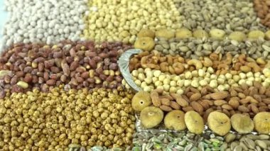 Kamera fındık makro çekim üzerinden hareket ediyor. Çeşitli fındıklar yaklaşıyor. ceviz, badem, fındık ve diğer fındıklar masada kurutulur. Yüksek kalorili vejetaryen yemeği. Kuru fındık. 4K Video.