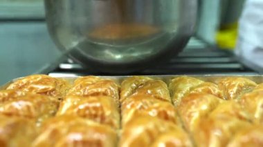 Baklava 'nın üzerine şurup döküyorum. Türk Baklava 'sına yeşil şam fıstıklı tatlı, katmanlı pastalı tatlı, doğranmış fındıkla dolu, şurup veya balla tatlandırılmış.
