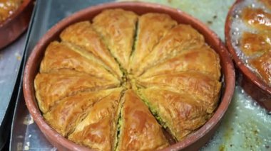 Baklava 'nın üzerine şurup döküyorum. Türk Baklava 'sına yeşil şam fıstıklı tatlı, katmanlı pastalı tatlı, doğranmış fındıkla dolu, şurup veya balla tatlandırılmış.