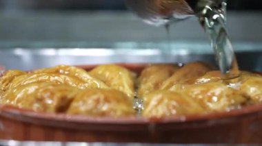 Baklava 'nın üzerine şurup döküyorum. Türk Baklava 'sına yeşil şam fıstıklı tatlı, katmanlı pastalı tatlı, doğranmış fındıkla dolu, şurup veya balla tatlandırılmış.