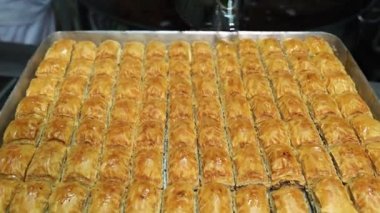 Baklava 'nın üzerine şurup döküyorum. Türk Baklava 'sına yeşil şam fıstıklı tatlı, katmanlı pastalı tatlı, doğranmış fındıkla dolu, şurup veya balla tatlandırılmış.