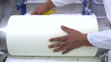 Otomatik hamur makinesiyle fillo hamur yapma işlemi. Bir gıda üretim tesisinde fillo hamuru için çarşaf yapıyorum. Ev yapımı hamur makası ve sedye. 4k video.