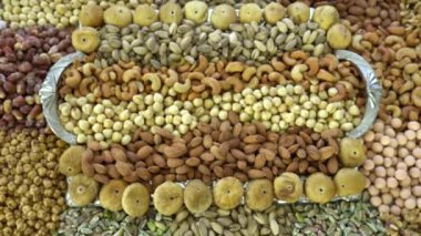 Kamera fındık makro çekim üzerinden hareket ediyor. Çeşitli fındıklar yaklaşıyor. ceviz, badem, fındık ve diğer fındıklar masada kurutulur. Yüksek kalorili vejetaryen yemeği. Kuru fındık. 4K Video.