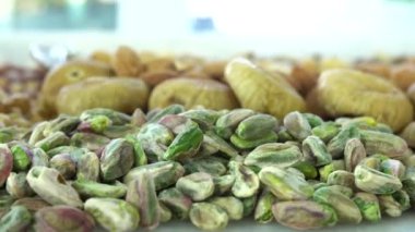 Kamera fındık makro çekim üzerinden hareket ediyor. Çeşitli fındıklar yaklaşıyor. ceviz, badem, fındık ve diğer fındıklar masada kurutulur. Yüksek kalorili vejetaryen yemeği. Kuru fındık. 4K Video.