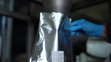 Endüstriyel kızartma ve üretim, kahve endüstrisi. Yakından bakınca, kahverengi taneler paketlere doldurulmak için dökülüyor..