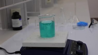 Renkli solüsyonu manyetik karıştırıcı ile karıştırıyorum. Kimyasal reaksiyon oluşumu. Video.