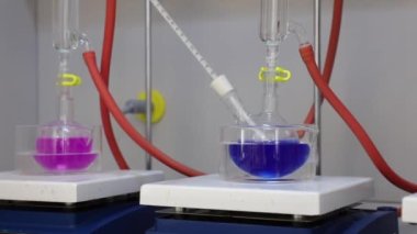 Renkli solüsyonu manyetik karıştırıcı ile karıştırıyorum. Kimyasal reaksiyon oluşumu. Video.