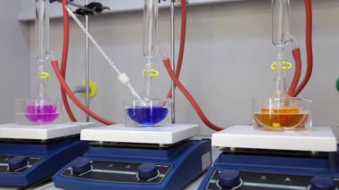 Renkli solüsyonu manyetik karıştırıcı ile karıştırıyorum. Kimyasal reaksiyon oluşumu. Video.