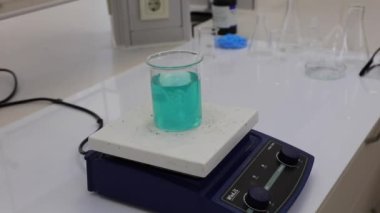 Renkli solüsyonu manyetik karıştırıcı ile karıştırıyorum. Kimyasal reaksiyon oluşumu. Video.