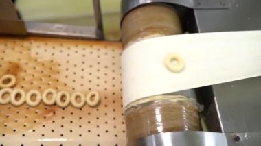 Kandil çörekleri. İşçiler gıda fabrikasındaki üretim hattında kandil simidi üretiyorlar. Üretim hattında, simit ve susam çubuklarının üzerine pekmez dökülüyor. Türkçe adı: Kandil Simidi. 4K