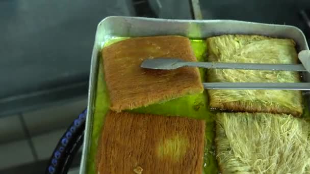 トルコのデザートカダイフとピスタチオパウダー ビルマのカダイフのトレイ ピスタチオ カダイフ デザート 伝統的なトルコ料理 ローカル名Sarma Kadayif 4Kビデオ撮影 — ストック動画