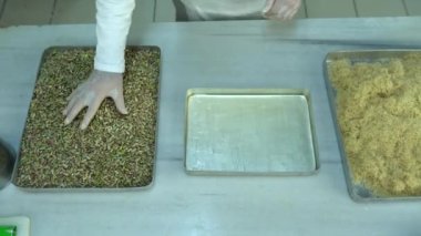 Türkiye, İstanbul - Türk tatlıları üreten gıda fabrikası, Pistachio Kadaif tatlısı. Akdeniz mutfağı lezzetlidir. Yerel adı fistikzade kadayif. Aşçılık aşamaları ve tepsiye bedava içki dökme. 4K Video çekimi.
