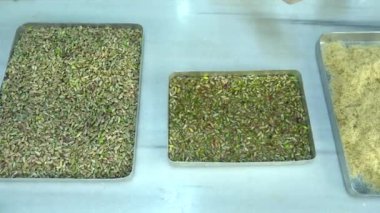 Türkiye, İstanbul - Türk tatlıları üreten gıda fabrikası, Pistachio Kadaif tatlısı. Akdeniz mutfağı lezzetlidir. Yerel adı fistikzade kadayif. Aşçılık aşamaları ve tepsiye bedava içki dökme. 4K Video çekimi.
