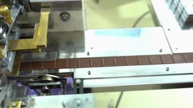 Bir fabrikada otomatikleştirilmiş çikolatalı pralin üretimi. Taşıyıcı banttaki çikolataların farklı tonları ve tatları toplanmaya hazırdır. Kusursuz döngü animasyonu. 4K HD