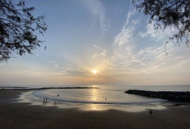 Dramatik bulutlar ve mavi gökyüzü ile okyanusun üzerinde güzel bir gün batımı