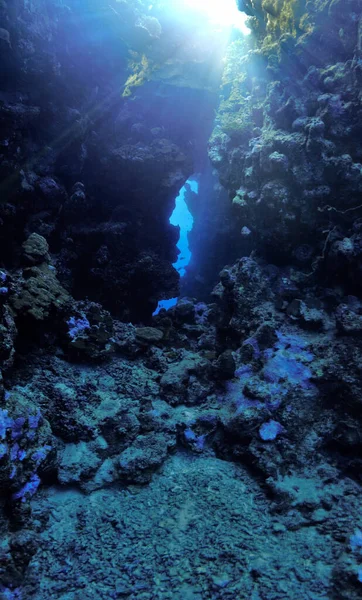 Underwater photography of beautiful light inside caves, tunnels and swim through. From a scuba dive in the sea.