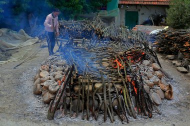 Kula, Türkiye - 13 Haziran 2021: El yapımı, geleneksel kilden pişirme yöntemi. Ahşap ateşle pişirdikten sonra, jöle kaplama yapılacak..