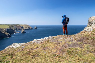 Adam fotoğraf çekiyor. Cornwall, Boscastle, İngiltere 'de güzel okyanus manzarası.