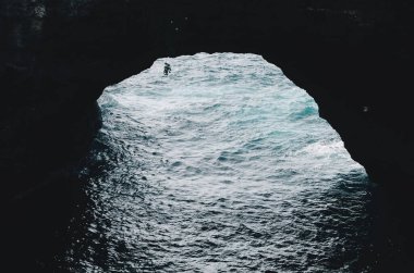 Bir deniz mağarasından dışarı bakıyorum. Gök mavisi renginde berrak su ve engebeli uçurumların manzarası