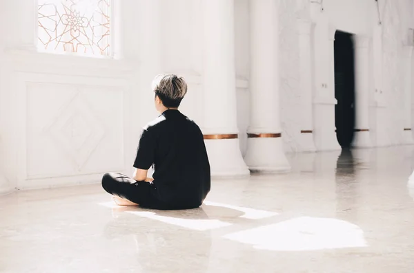 portrait of asian youth in mosque praying solemnly