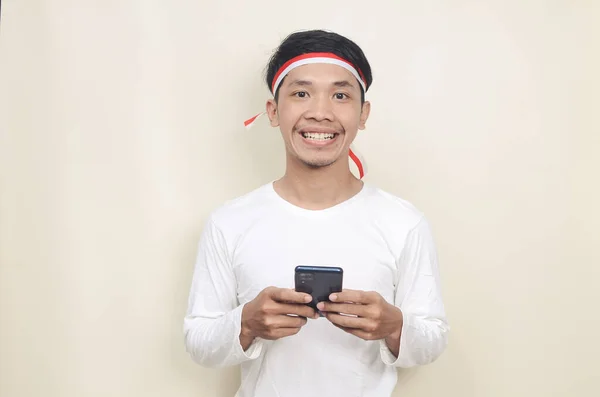 Индонезиец Улыбается Держа Руках Мобильный Телефон Время Празднования Дня Независимости — стоковое фото