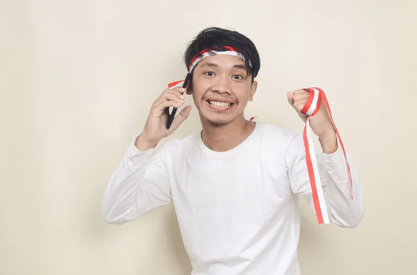 Indonesian Man Smiling While Holding Mobile Phone Independence Day Celebration — 스톡 사진