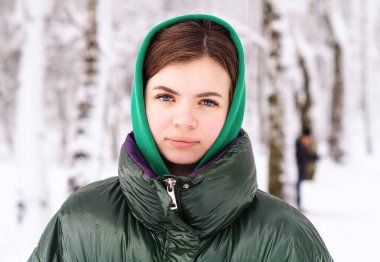 Çekici bir genç kızın kış portresi. Kışın karlı bir ormanda 18 yaşında tatlı, genç bir kız. Kışın açık havada gülümseyen güzel bir kadın. Kadın güzelliği kavramı.