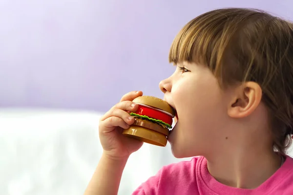 Симпатичная Малышка Гамбургером Руках Маленькая Девочка Шутку Кусает Детский Игрушечный — стоковое фото