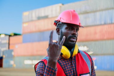 Gülümseyen bir konteynır işçisinin portresi ya da şapkalı neşeli bir ustabaşı. Kırmızı Bulanık Kutu Kutusu Arkaplan Başarı ve taşınan endüstriyel ürünler lojistik ithalat-ihracat kavramı