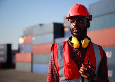 Mühendis ustabaşı, erkek Afrikalı Amerikalı, denetimi kontrol ediyor. Uluslararası nakliye şirketleri için konteyner deposu endüstriyel mallar, lojistik, ithalat-ihracat ticari taşımacılık