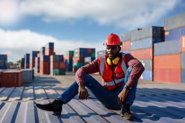 Mühendis ustabaşı, erkek Afrikalı Amerikalı, denetimi kontrol ediyor. Uluslararası nakliye şirketleri için konteyner deposu endüstriyel mallar, lojistik, ithalat-ihracat ticari taşımacılık