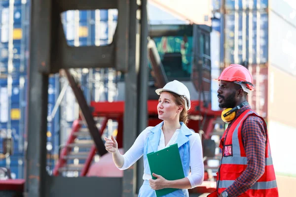 Afrika kökenli Amerikalı erkekler ve beyaz kadınlardan oluşan bir takım kask takıyor. Konteynırların kargo gemileri, konseptler, depolama, ithalat, ihracat, endüstriyel lojistik hizmetlerinden yüklenmesini kontrol etmeye çalış.