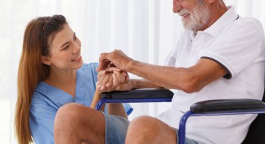 female doctor helping care holding hands to encourage talk Caucasian older man, older adult, patient in a wheelchair at nursing ward health concept Help restore aging, medical and retirement.