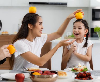 Büyük, mutlu bir Asyalı aile evlerinde bir masada yemek yiyerek vakit geçirir. Küçük kızlar özgürce konuşup oyun oynuyorlar. Som eğleniyor. Baba, anne, teyze. Mutlu aile ilişkileri konsepti. Yaşam biçimi.
