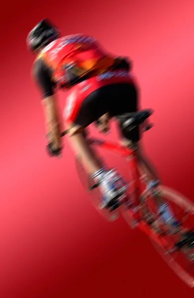 Racing cyclists against a red background — Stock Photo, Image