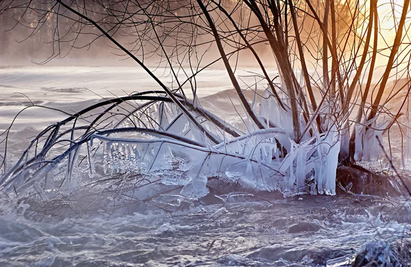 Ландшафтний знімок взимку зі снігом, льодом і бурульбашками на сході сонця — стокове фото
