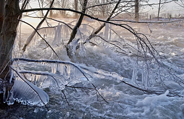 Ландшафтний знімок взимку зі снігом, льодом і бурульбашками на сході сонця — стокове фото