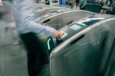 Metroda turnikeden geçen yolcular, Singapur 'da toplu toplu taşıma sistemi, pasif bariyer turnikesi, insan hareketi için yavaş deklanşör hızı