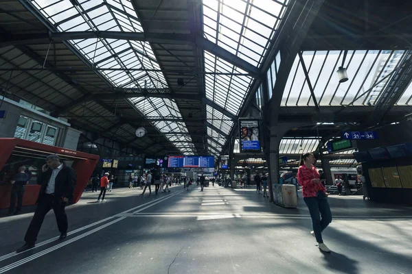 Passengers commute in main station, Zurich HB, the largest railway station in Switzerland. Interior shot of Zurich Hauptbahnhof. Beautiful roof structure at daytime.