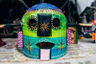 colorful ama huma masks are displayed at market stall